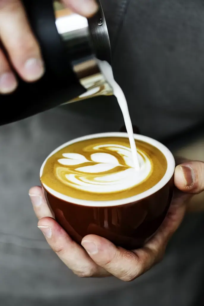 Latte art being poured into a cappuccino